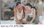 Two positive female dressmakers drawing dress design on tablet in tailor's shop. Стоковое видео, видеограф Яков Филимонов / Фотобанк Лори