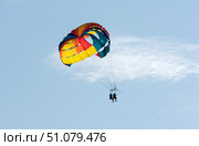 Parasailing is a type of extreme entertainment in which a person rises into the air on a parachute attached to a boat. The speed of the vessel creates lift, allowing you to enjoy flying over the sea. Стоковое фото, фотограф Анищенко Геннадий / Фотобанк Лори