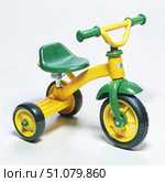 Yellow and Green Tricycle for Young Children. Generative AI. Стоковое AI-изображение, AI-художник Roman Zavorotny / Фотобанк Лори