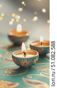 Three colorful diya lamps on a decorative surface. The lamps are glowing, symbolizing the festival of lights. Soft bokeh lights enhance the festive atmosphere. Стоковое AI-видео, аниматор Nart / Фотобанк Лори
