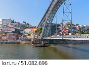 The boat floats on the river Douro under the bridge Dom Luis I Bridge. Scenic view of Ribeira from Vila Nova de Gaia. Porto, Portugal (2018 год). Стоковое фото, фотограф Вера Федорова / Фотобанк Лори