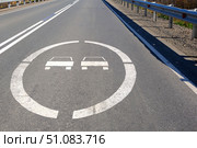A road sign on the asphalt in front of the bridge prohibits overtaking. Стоковое фото, фотограф lyudmila Soloveva / Фотобанк Лори