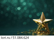 Christmas Golden star, shiny shimmering against a dark green background and bokeh lights. Abstract festive atmosphere for special events. Joyous vibe. Star-shaped gold decoration. Elegant night banner. Стоковое AI-изображение, AI-художник Марина Демидюк / Фотобанк Лори