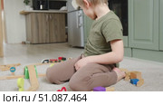 Cute little blonde child boy sitting on the floor playing with wooden toy train. Toddler kid plays railway. Made of natural materials. Birthday gift. Preschool employment. Brain, coordination exercise. Стоковое видео, видеограф Марина Демидюк / Фотобанк Лори