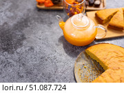 A glass teapot with a beautiful orange pie drink on a gray table. Стоковое фото, фотограф Alexandra Aleroewa / Фотобанк Лори