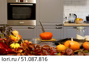 On the table is an orange pumpkin with a knife stuck in it. Kitchen. Стоковое фото, фотограф Alexandra Aleroewa / Фотобанк Лори
