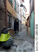 Narrow cobbled street of downtown. Authentic old town Porto, Portugal. Drying of washed laundry (2018 год). Стоковое фото, фотограф Вера Федорова / Фотобанк Лори
