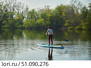 A woman swims on a sapboard on the lake. Water entertainment. Стоковое фото, фотограф Наталия Кирсанова / Фотобанк Лори