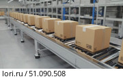 Boxes are moving on a conveyor belt in a warehouse. The scene shows an automated sorting system for packaging and shipping processes. Стоковое AI-видео, аниматор Nart / Фотобанк Лори
