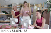 Elderly woman demonstrate fabrics and models dress sleeves live on client, girl seamstress sewing. Стоковое видео, видеограф Яков Филимонов / Фотобанк Лори