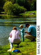 A family of three is fishing in a lake. Russia. Moscow. 17.08.25. Редакционное фото, фотограф Ярославский Максим / Фотобанк Лори