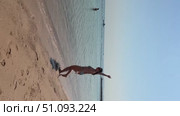 A 50-year-old European woman in a swimsuit walks along the beach in Doha, Qatar. Стоковое видео, видеограф IRYNA ZAKHARANKA / Фотобанк Лори