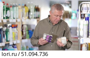 European chooses with interest scented candles made of paraffin and soy wax in the household section of a supermarket. Стоковое видео, видеограф Яков Филимонов / Фотобанк Лори