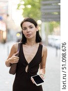 Slender female brunette with phone walks in vicinity of Passeig Nou in Barceloneta. Стоковое фото, фотограф Яков Филимонов / Фотобанк Лори