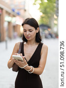 Slender female brunette with phone walks in vicinity of Passeig Nou in Barceloneta. Стоковое фото, фотограф Яков Филимонов / Фотобанк Лори