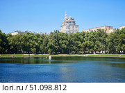Moscow, Russia. - May 29, 2025: Patriarch's Ponds. "The Patriarch" apartment building is visible in the distance. Редакционное фото, фотограф Наталия Кирсанова / Фотобанк Лори