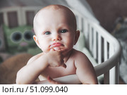 Tiny Philosopher Ponders Existence Inside White Crib. Стоковое фото, фотограф Aleksandr Golubev / Фотобанк Лори