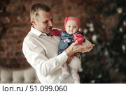 Dad Holds His Baby Daughter in His Arms Indoors at Home With Affection. Стоковое фото, фотограф Aleksandr Golubev / Фотобанк Лори