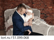 Loving Father Gently Holds His Baby Daughter Indoors With Brick Wall. Стоковое фото, фотограф Aleksandr Golubev / Фотобанк Лори