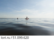 Морской пейзаж, фигуры людей на горизонте, человек катается по воде на сап борде, пляжный отдых под открытым небом. Стоковое фото, фотограф Мария L. / Фотобанк Лори