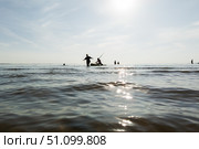 Водный пейзаж, люди на горизонте, человек катается по воде на сап борде, пляжный отдых под открытым небом в солнечный день. Стоковое фото, фотограф Мария L. / Фотобанк Лори