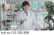Female pharmacist recommending ointment at pharmacy counter. Стоковое видео, видеограф Яков Филимонов / Фотобанк Лори