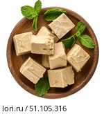 Wooden plate presenting delicious coffee fudge decorated with fresh mint leaves. Стоковое AI-изображение, AI-художник Иван Рябоконь / Фотобанк Лори