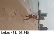 A 50-year-old European woman in a swimsuit walks along the beach in Doha, Qatar. Стоковое видео, видеограф IRYNA ZAKHARANKA / Фотобанк Лори