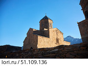 Stepantsminda, Georgia - January 03, 2023: Gergeti Church of the 14th century at the foot of Mount Kazbek. Редакционное фото, фотограф Наталия Кирсанова / Фотобанк Лори