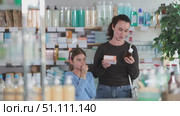 Adult woman chooses medicine for her coughing daughter. Стоковое видео, видеограф Яков Филимонов / Фотобанк Лори