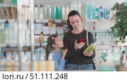 Woman with daughter scanning qr code of shampoo or shower gel. Стоковое видео, видеограф Яков Филимонов / Фотобанк Лори