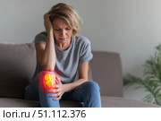 Knee pain icon. Joint pain, Arthritis and tendon problems. Woman in jeans sitting sofa, touching nee at pain point. Mature person feeling unwell, suffering from pain in leg. Red effect painful injury. Стоковое AI-изображение, AI-художник Марина Демидюк / Фотобанк Лори