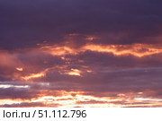 A dramatic sunset paints the sky with shades of purple and orange, highlighting the clouds. Concept of: Atmospheric beauty. Стоковое фото, фотограф Ольга Петрова-Апостолова / Фотобанк Лори