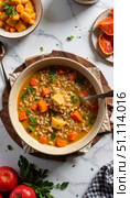 Barley soup with carrots and celery in bowl on a marble table. Стоковое AI-изображение, AI-художник DeFusum / Фотобанк Лори