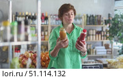 Adult woman chooses peach and tomato juices. Стоковое видео, видеограф Яков Филимонов / Фотобанк Лори