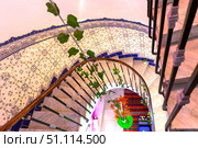 Spiral staircase. Top view. Chandelier and ceramic tiles on the wall. Стоковое фото, фотограф Евгений Ткачёв / Фотобанк Лори