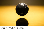 Abstract black marble sphere levitating over golden water surface. Luxury minimalist background with 3d stone egg reflecting in gold. Zen concept of balance. Стоковое AI-изображение, AI-художник Павел Муравьев / Фотобанк Лори