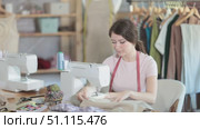 Woman seamstress sews on sewing machine in workshop. Стоковое видео, видеограф Яков Филимонов / Фотобанк Лори
