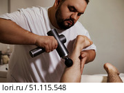 Man Using Percussion Massager Gun for Leg Recovery at Home. Стоковое фото, фотограф Aleksandr Golubev / Фотобанк Лори