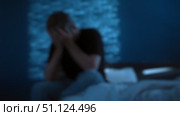 Blurred image, man sits on the edge of his bed, overwhelmed by stress. Стоковое видео, видеограф Arsenii Palivoda / Фотобанк Лори