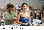 Middle-aged male tailor measuring female client in sewing workshop. Стоковое фото, фотограф Яков Филимонов / Фотобанк Лори