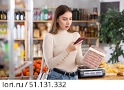 Girl scan QR-code on raw pork sausages in store. Стоковое фото, фотограф Яков Филимонов / Фотобанк Лори