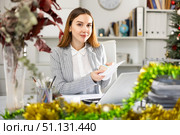 Woman office worker with wage packet in Christmas decorated office. Стоковое фото, фотограф Яков Филимонов / Фотобанк Лори