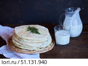 Hot Ossetian pie with cheese and herbs on the table with fermented milk national drink. Стоковое фото, фотограф Наталия Кирсанова / Фотобанк Лори