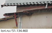 Rain trickles down a rusty metal gutter, showcasing a weathered roof. The gray sky adds a somber tone, while droplets create a soothing rhythm against the surface. Slow motion of rain. Стоковое видео, видеограф Воловодов Владимир / Фотобанк Лори