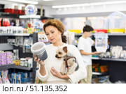 Woman with Yorkshire terrier choosing dry dog food in pet store. Стоковое фото, фотограф Яков Филимонов / Фотобанк Лори