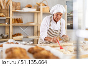 Elderly woman baker greases dough. Стоковое фото, фотограф Яков Филимонов / Фотобанк Лори