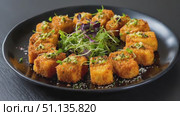 Golden polenta cubes resting on black plate, showcasing crispy texture, herb pesto, verdant microgreens accenting gourmet appetizer. Стоковое AI-видео, аниматор Юрий Поздников / Фотобанк Лори