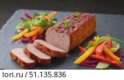 Juicy roasted pork tenderloin, expertly sliced and presented on a black slate plate, is accompanied by a vibrant salad of colorful bell peppers, red onion, and fresh herbs. Стоковое AI-видео, аниматор Юрий Поздников / Фотобанк Лори