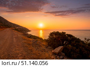 Sunrise on the island of Crete near Spinalonga with sea coast, rocks and dirt road. (2019 год). Стоковое фото, фотограф Емельянов Евгений Викторович / Фотобанк Лори